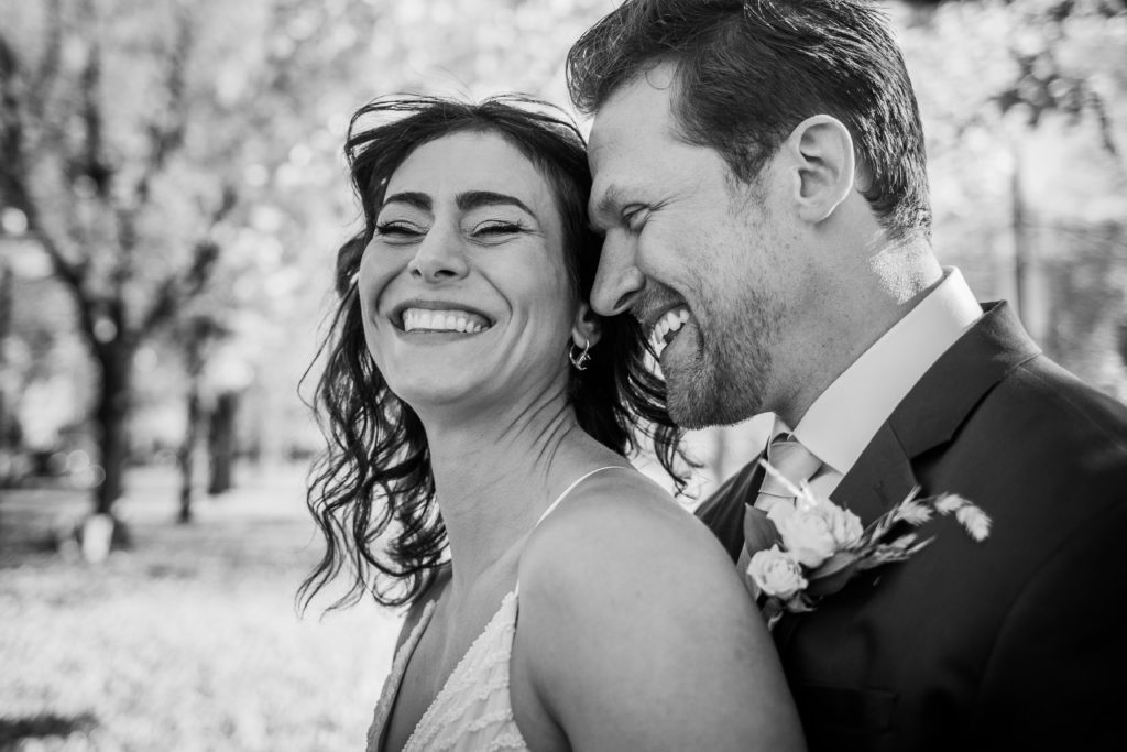 Bride and groom laugh together after seeing each other for the first time on Logan Boulevard in Chicago