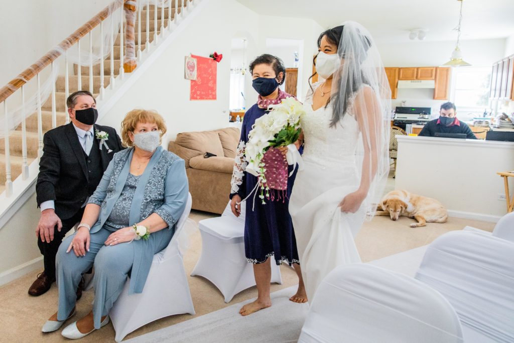 Masked bride smiles at groom at their Zoom Wedding