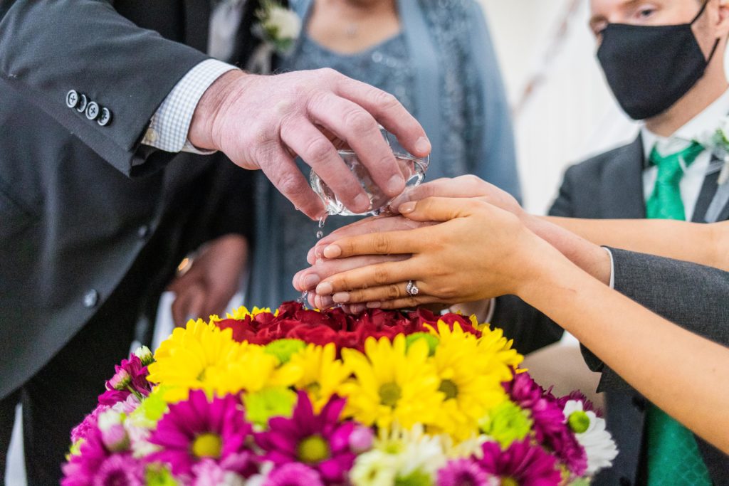 Water is poured of the hands of the bride and groom during the Thai water ceremony