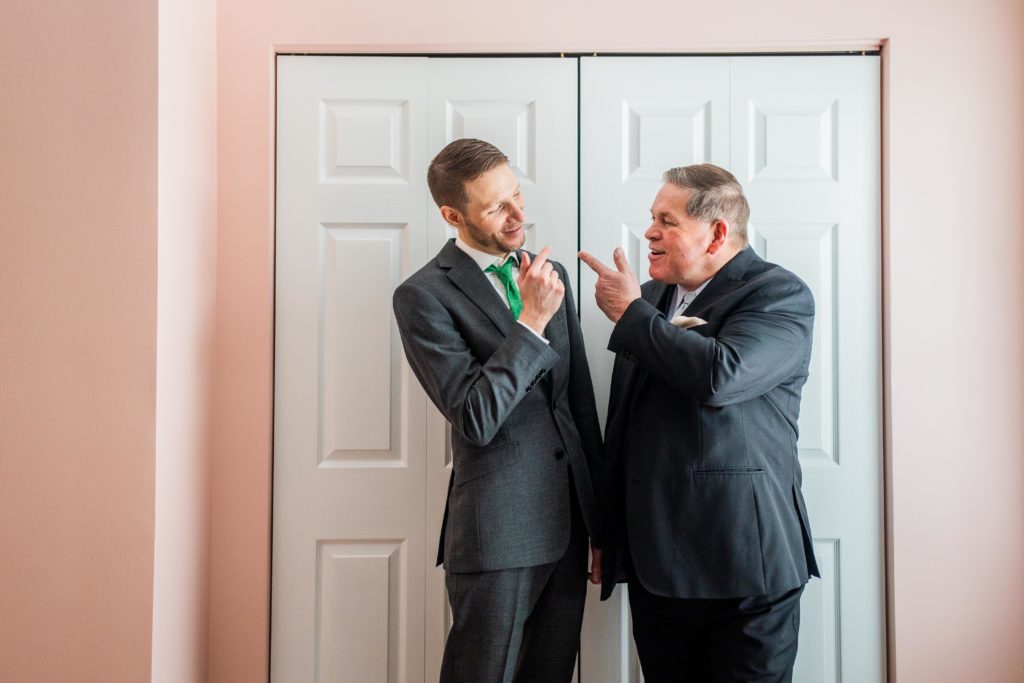 Groom and father making jokes together