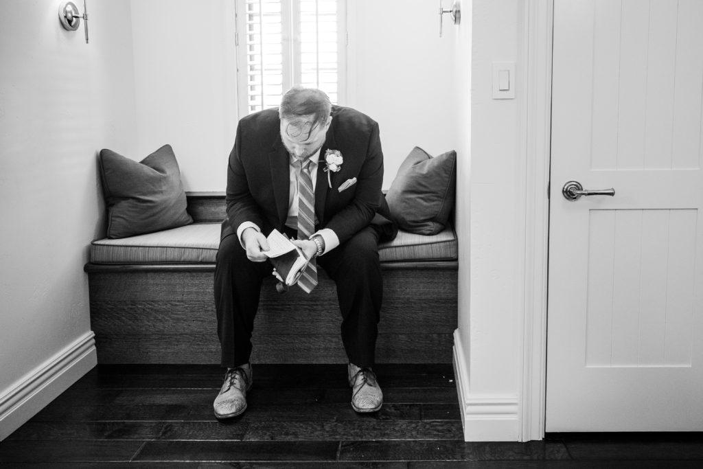 Groom sitting on the bench while reading a letter