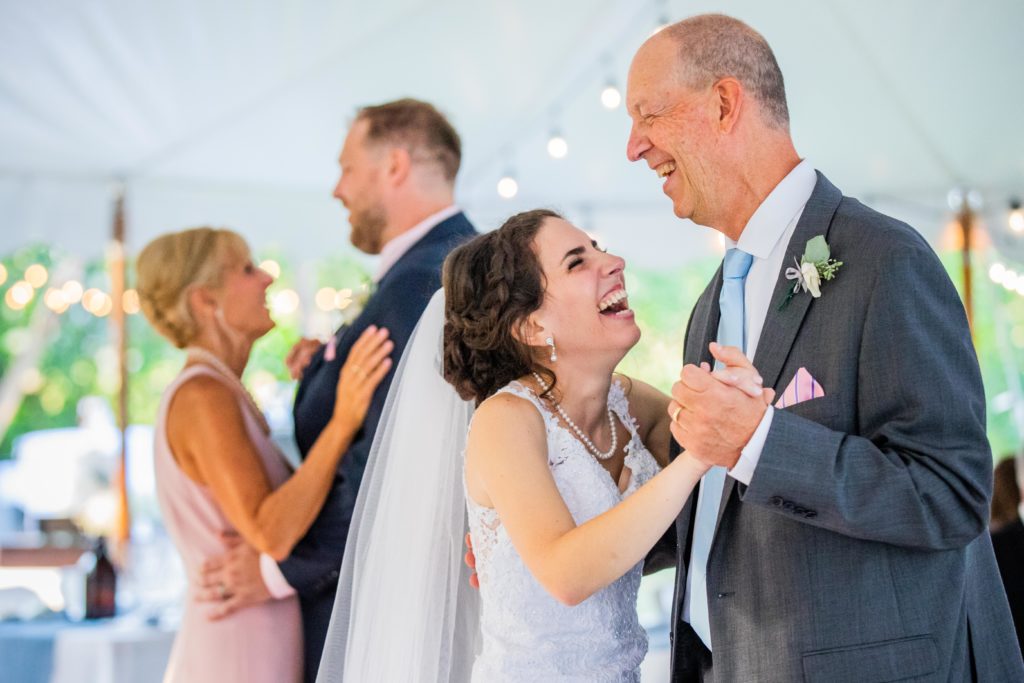 Bride laughs while dancing with her father-in-law during their Labor Day Weekend Wedding in Lake Bluff