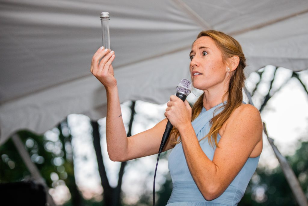 Maid of Honor holds up a test tube while making a speech