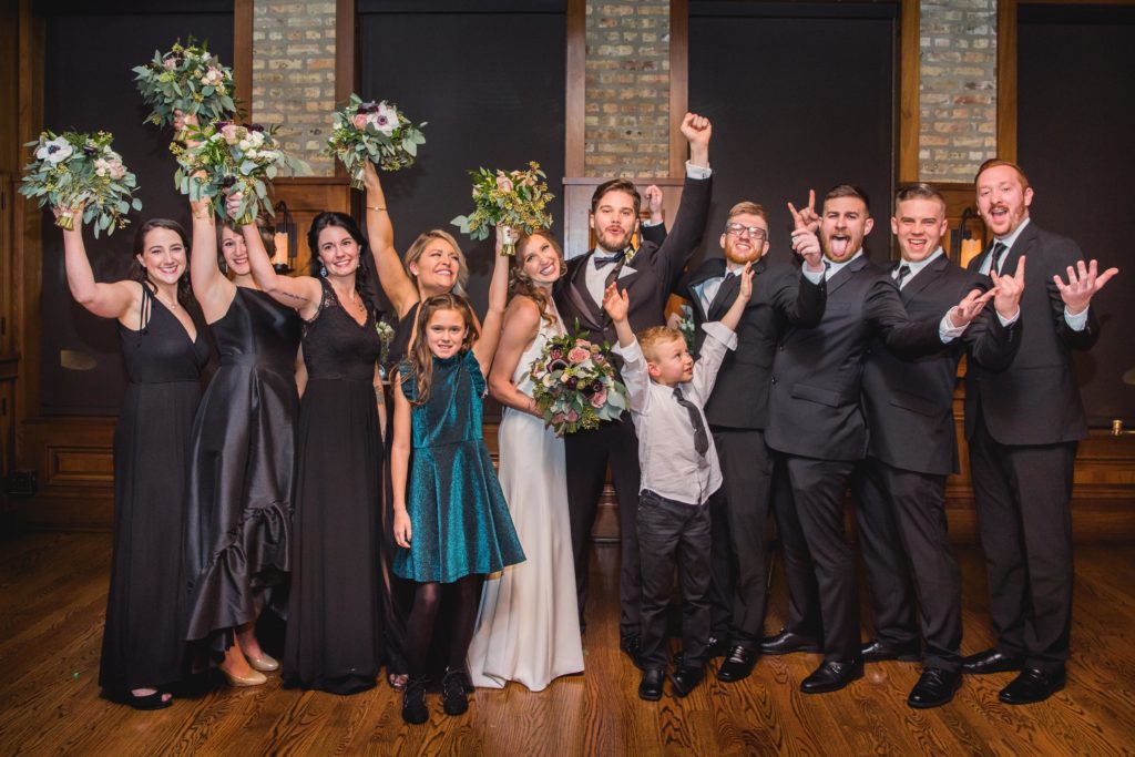 Wedding party cheering and holding their hands up