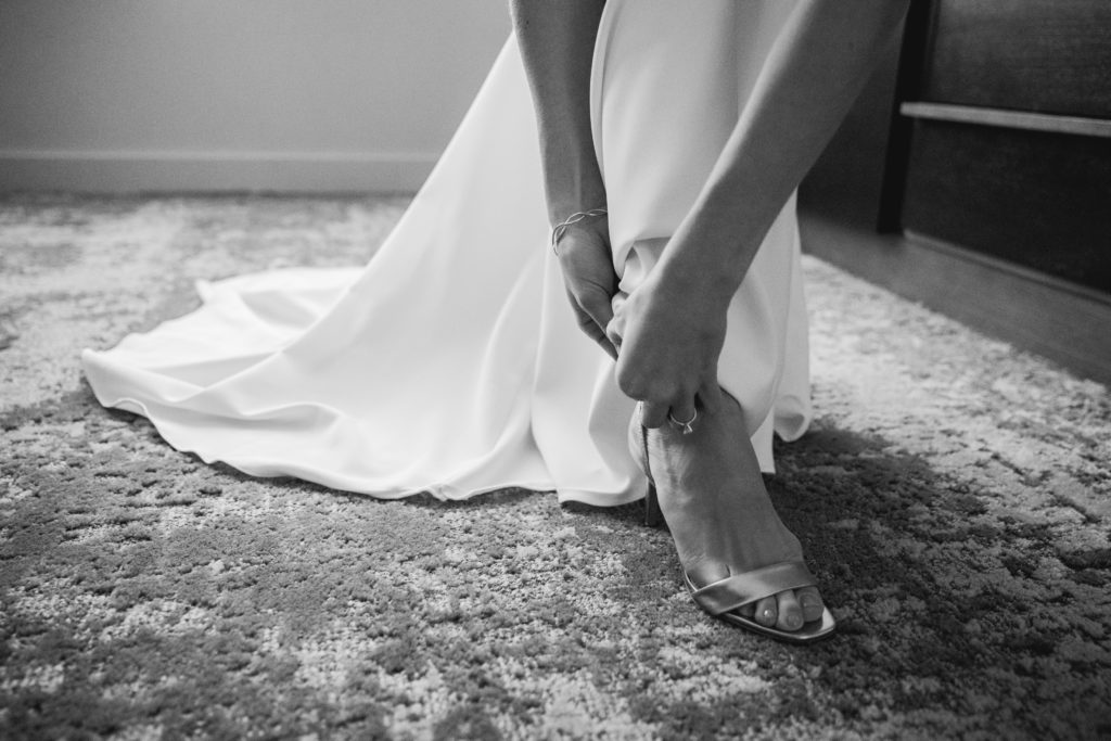 Bride leaning down to put on her shoes