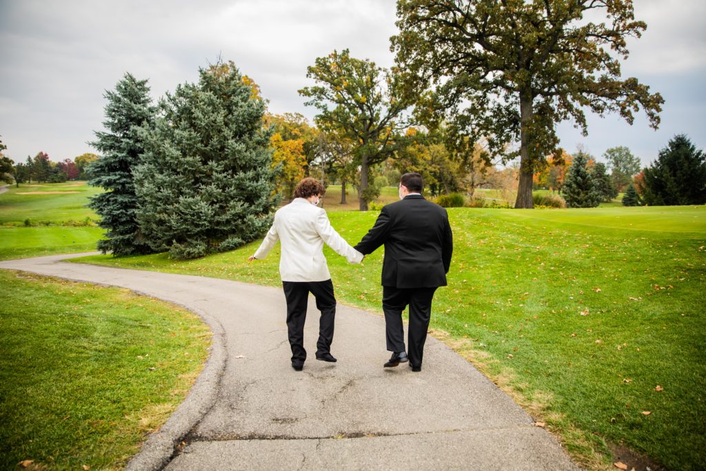 Grooms walking hand in hand at their Silver Lake Country Club Wedding