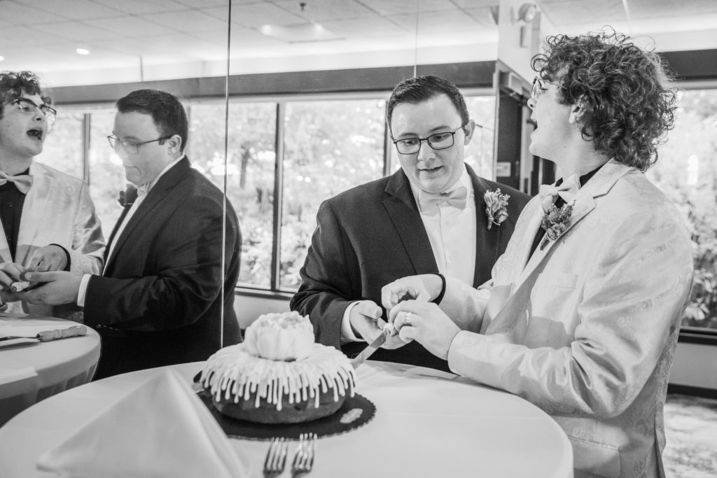 Grooms argue while cutting the cake