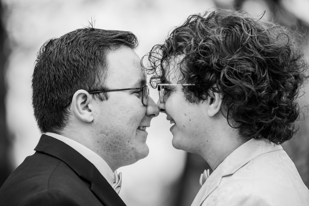 Grooms touching noses and smiling