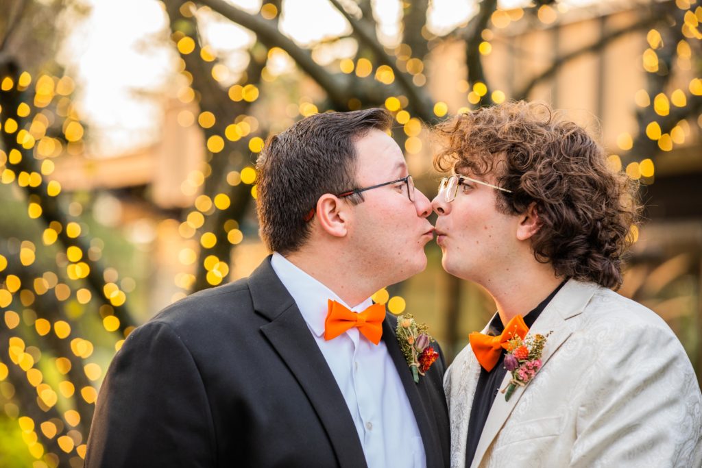 Couple makes a silly face while kissing in a courtyard
