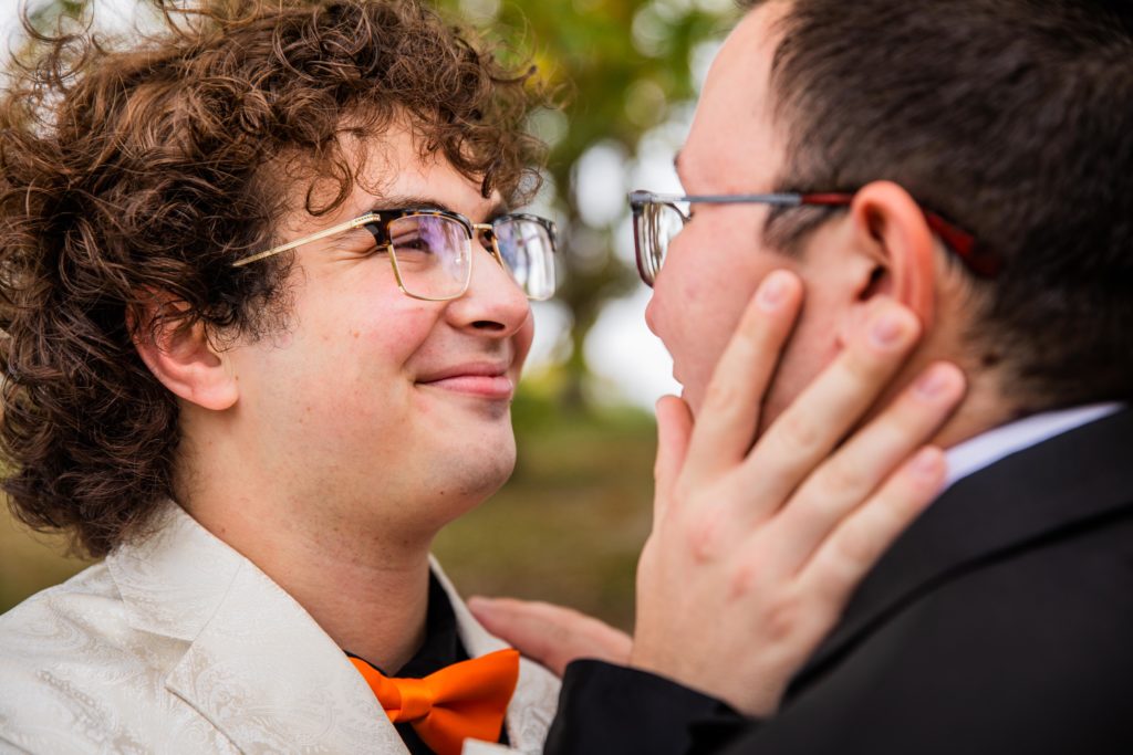 Grooms smiling while holding each other's faces