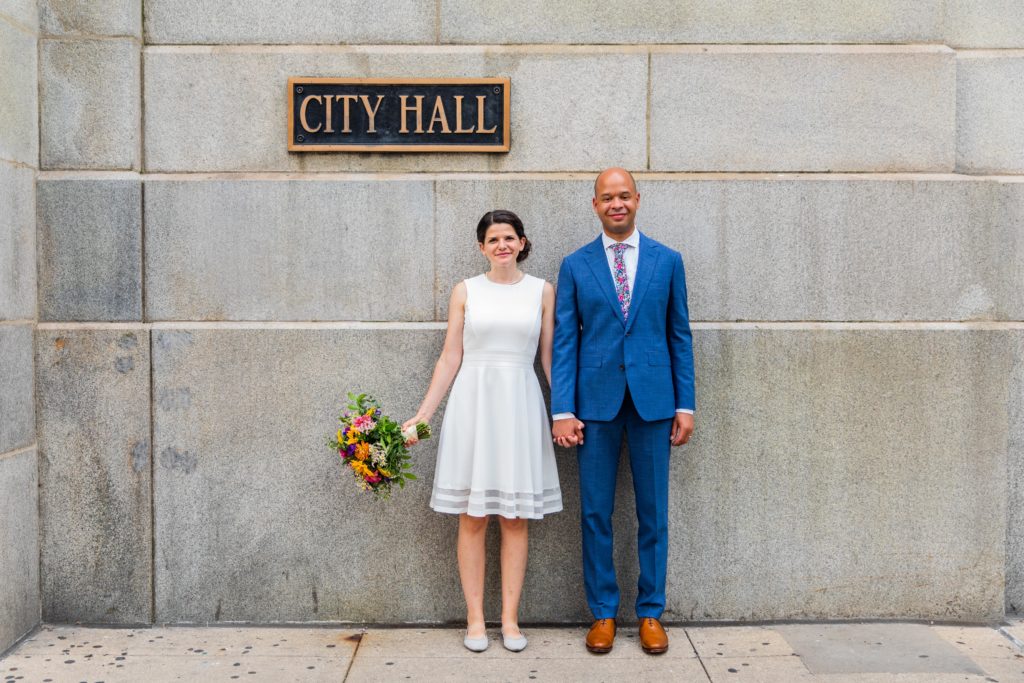 Couple standing outside the Chicago City Hall sign