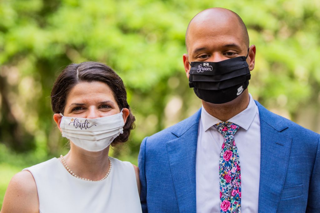 Bride and groom pose for a portrait while wearing matching Bride and Groom masks
