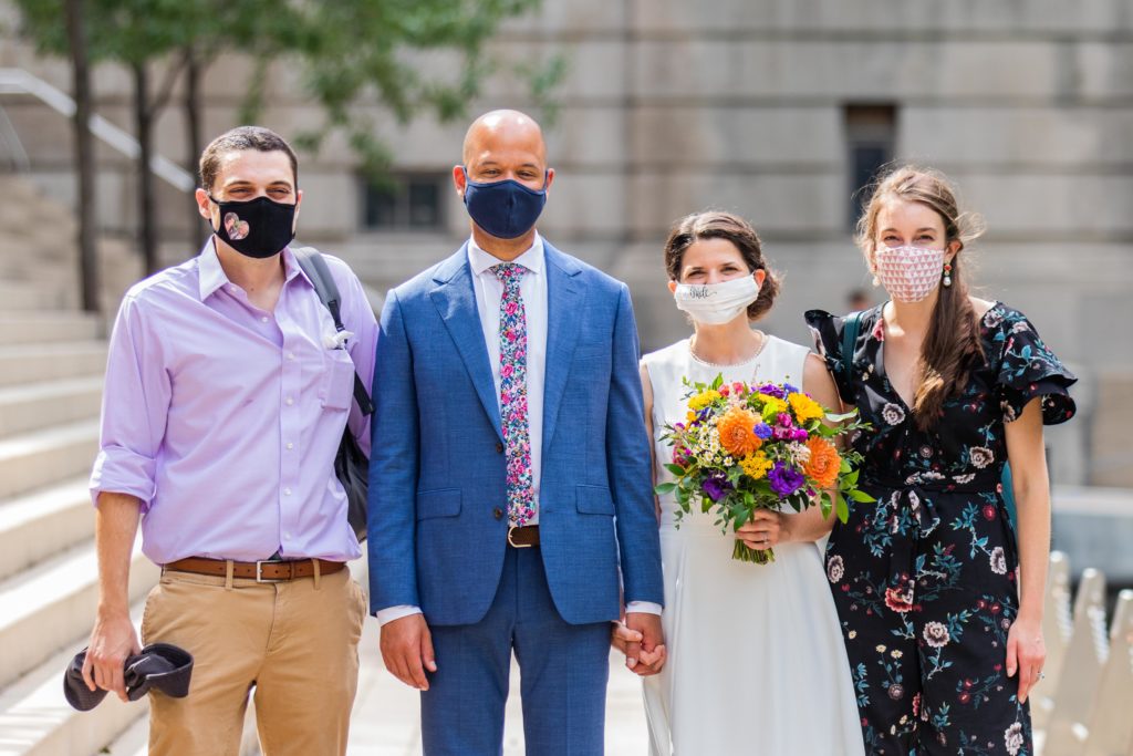 Masked bride and groom pose with masked friends