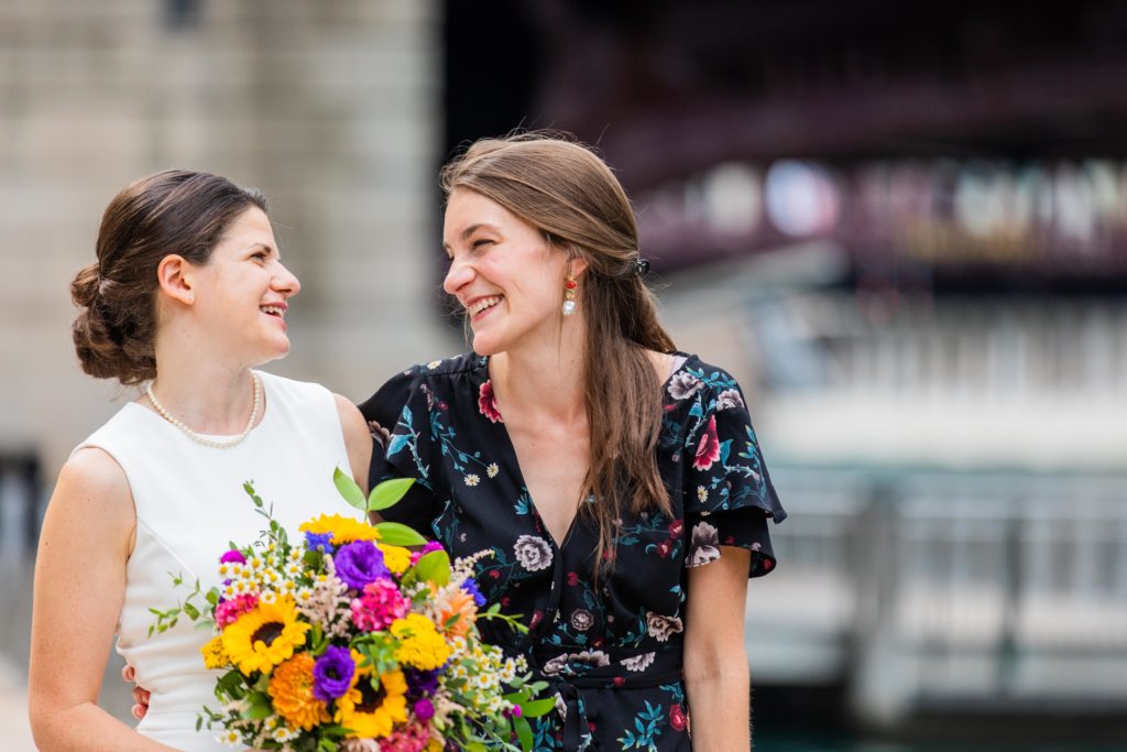 Bride laughs with her best friend near the Chicago Riverwalk