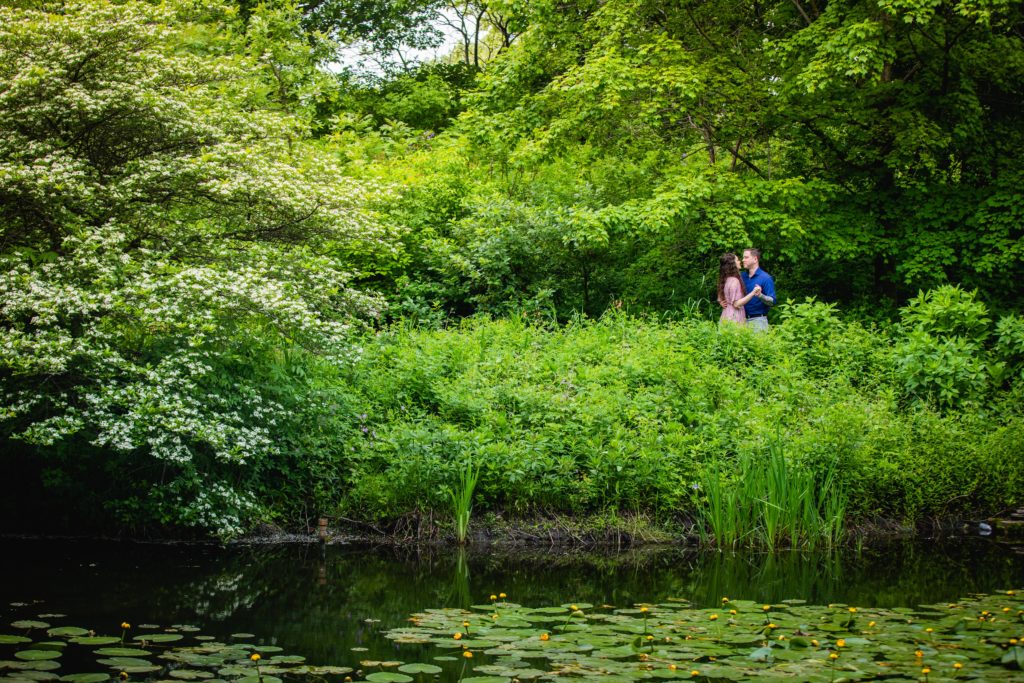 Man and woman dancing in the bishes by a lily pond