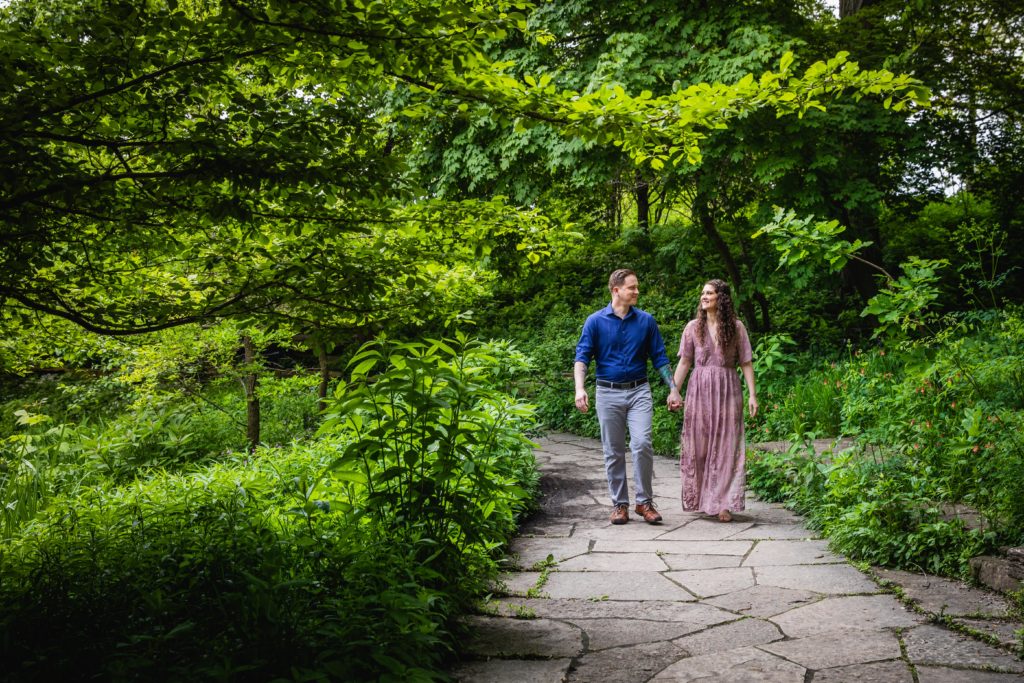Couple walking hand in hand in a garden