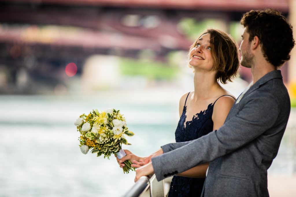 Bride and groom looking under the bridge by the Chicago River