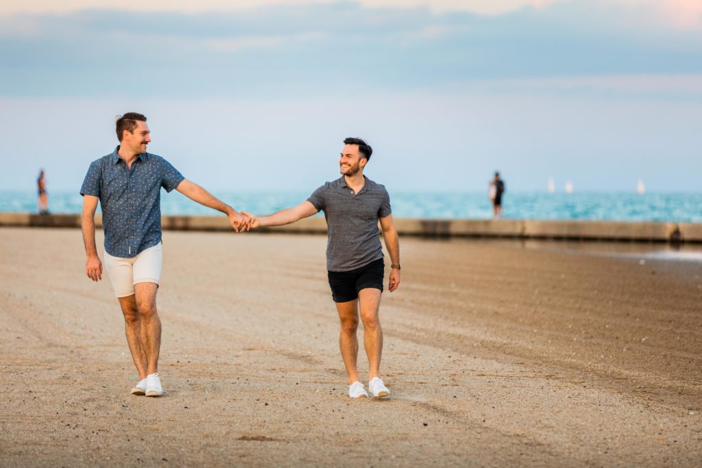 Men walking together on the beach at sunset