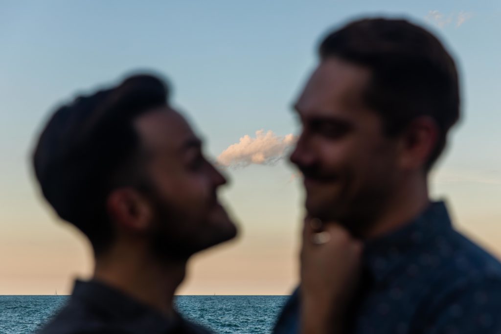 Man holding boyfriend's chin by the water at North Avenue Beach