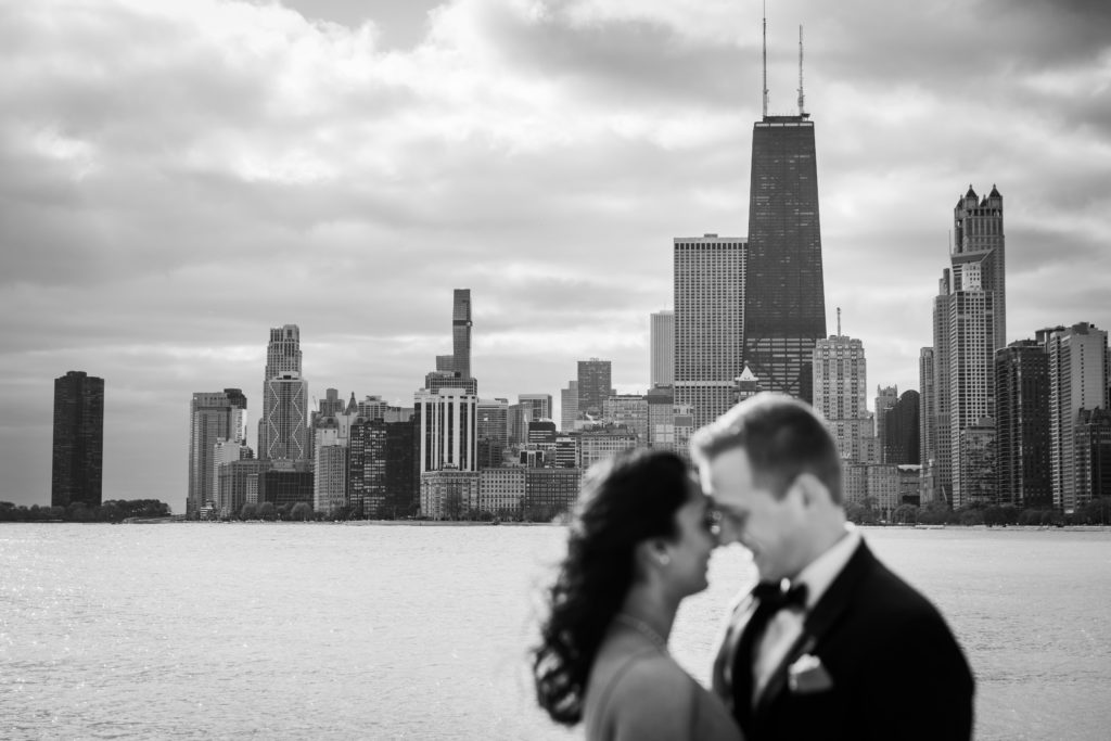 Bride and groom touching foreheads by the Chicago Lakefront