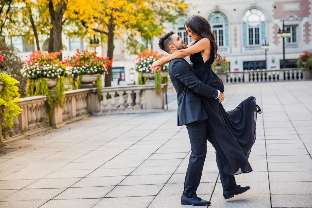 Man spinning woman while smiling during their Art Institute Engagement Session
