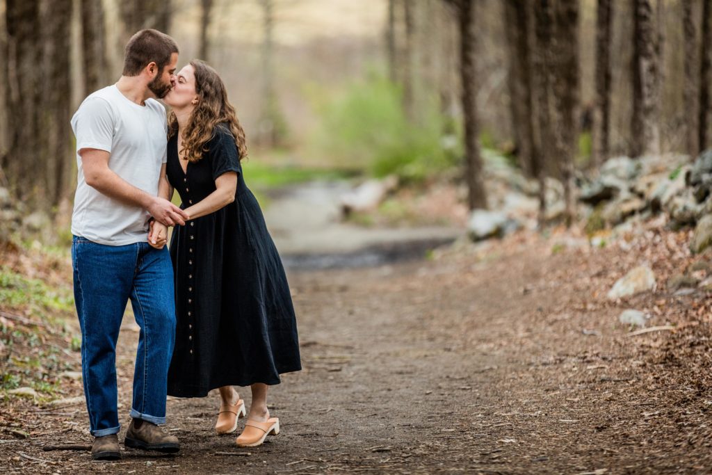 Woman kiss while walking through the woods in the Ward Pound Ridge Reservation