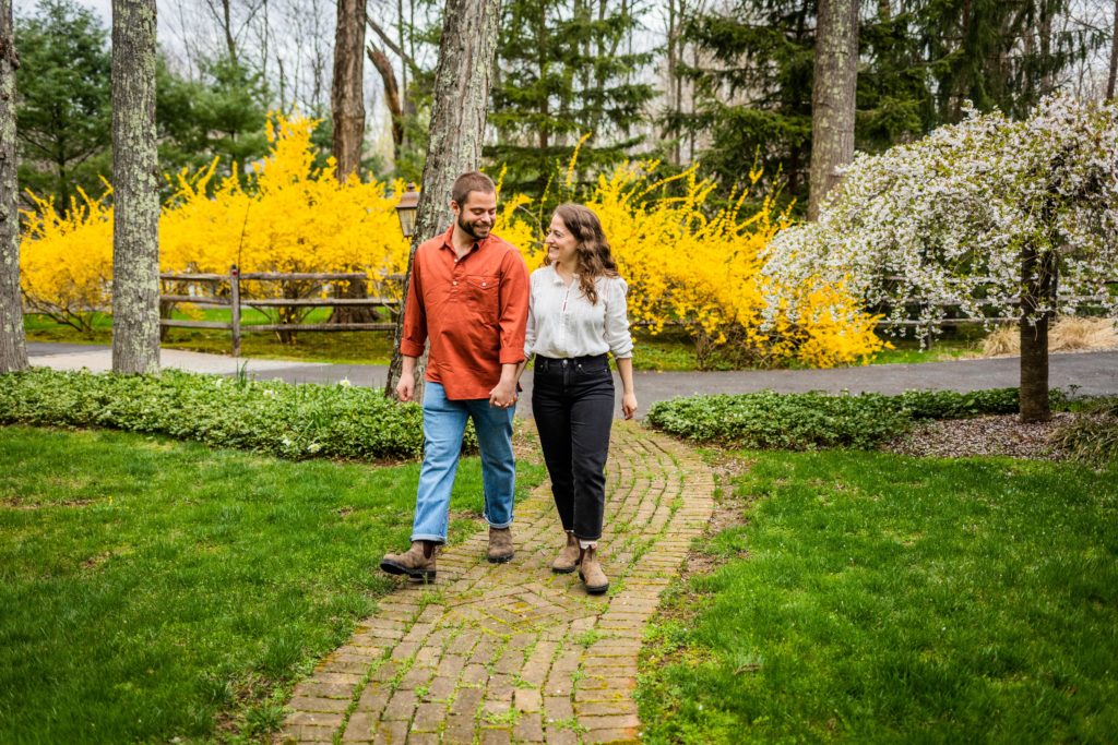 Couple look at each other while walking down a garden path in Bedford