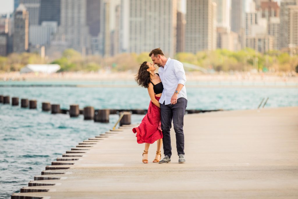 Man and woman lean in for a kiss in front of Lake Michigan