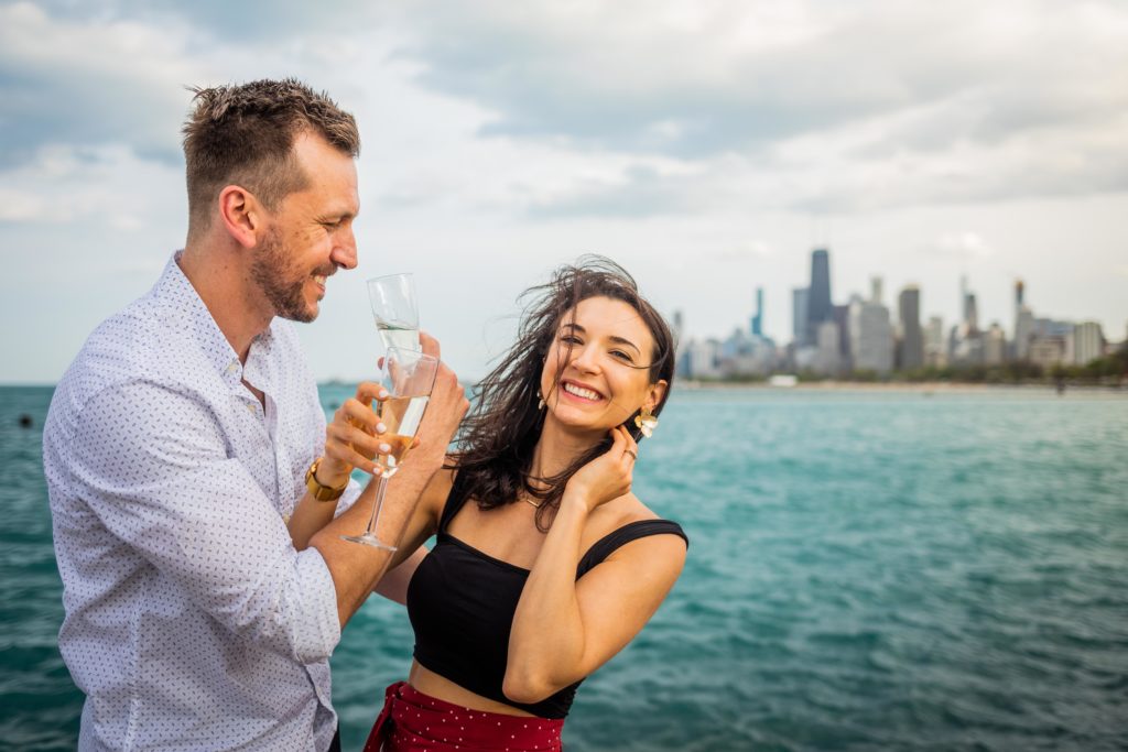 Man and woman smile as they drink champagne from flutes
