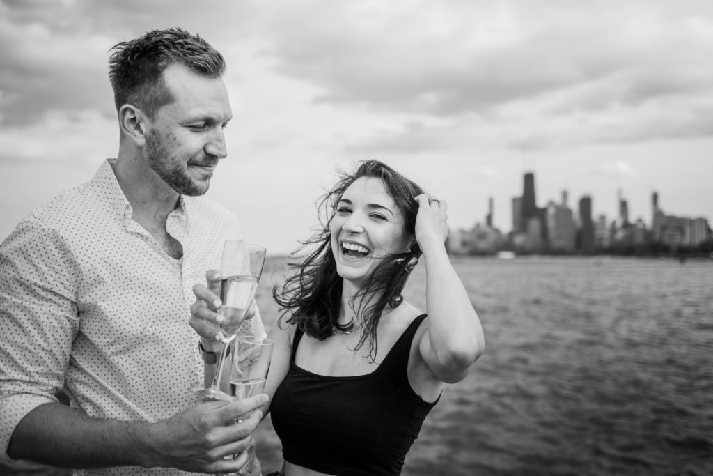 Couple laugh and smile as they drink champagne from flutes