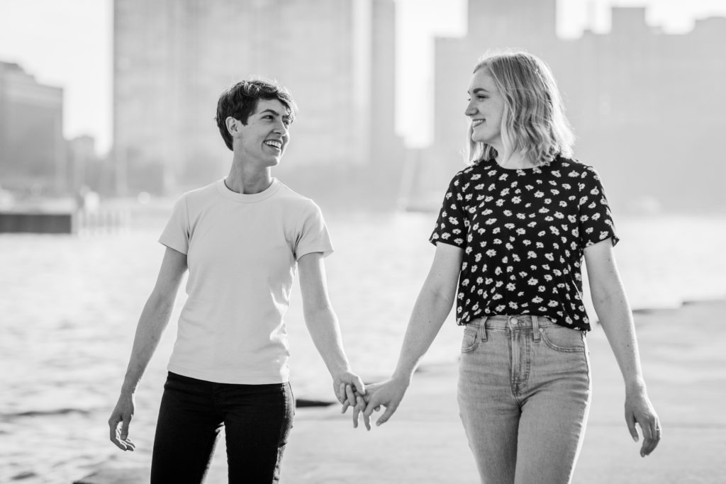 Queer woman smiling at each other while holding hands at Belmont Harbor