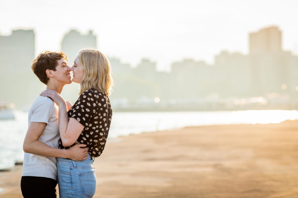 Women embracing for a kiss during their engagement session at belmont harbor