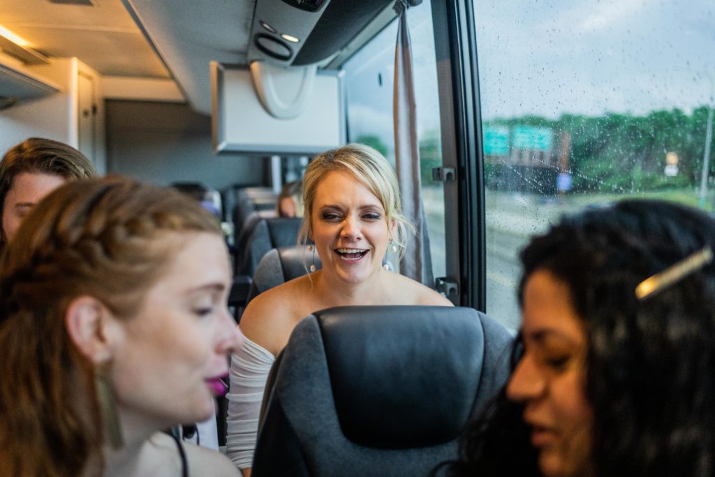 Bride laughs on the bus while on the way to their Big Star Reception