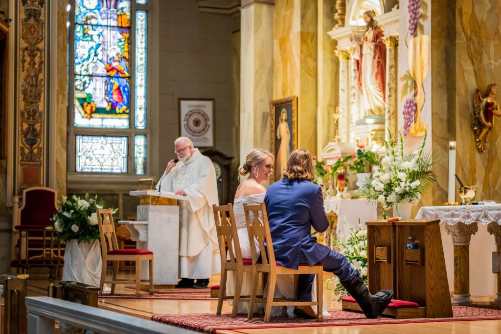 Bride laughs at the groom while they sit during their ceremony