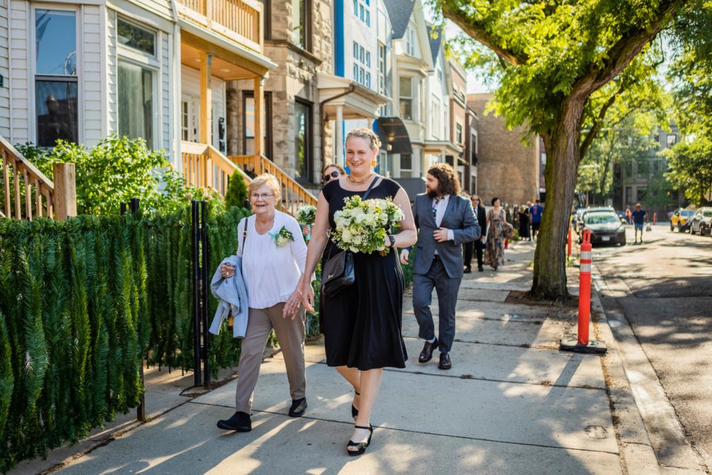 Sister of the bride and her grandmother walk down the sidewalk to the Big Star reception