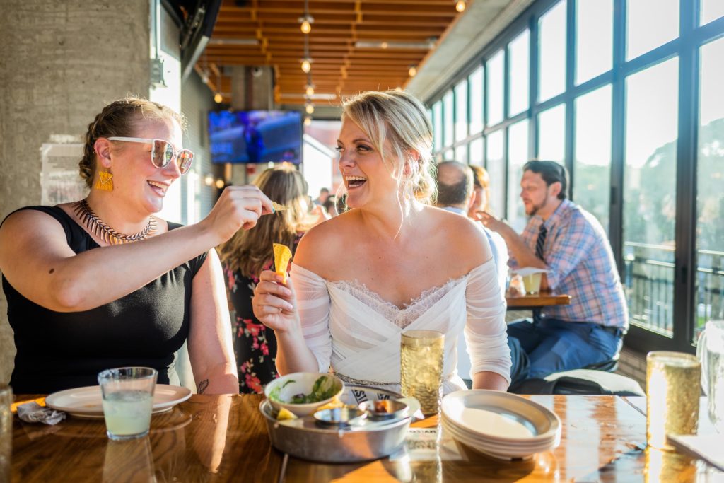 Bride and her sister cheersing with chips