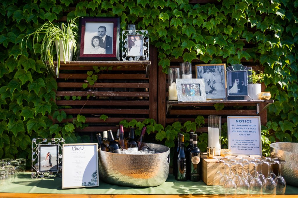 Pictures of past weddings in frames next to wine
