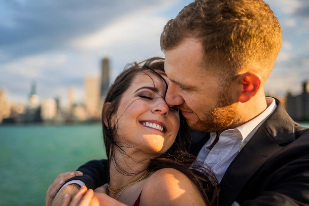 Man and woman touching noses and smiling during their North Ave Beach Engagement Session
