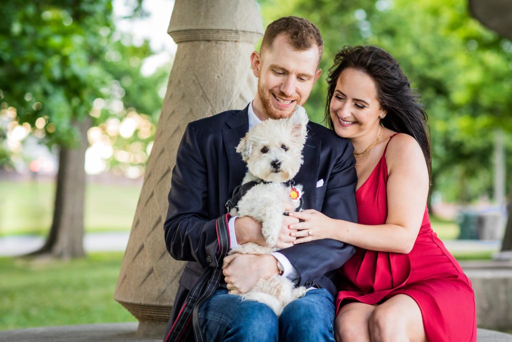 Couple smiling while holding their dog