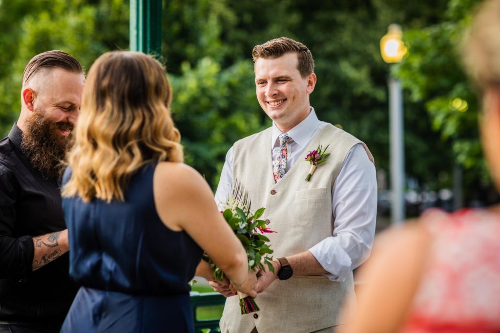 Groom looks at the bride as they get married in Welles Park