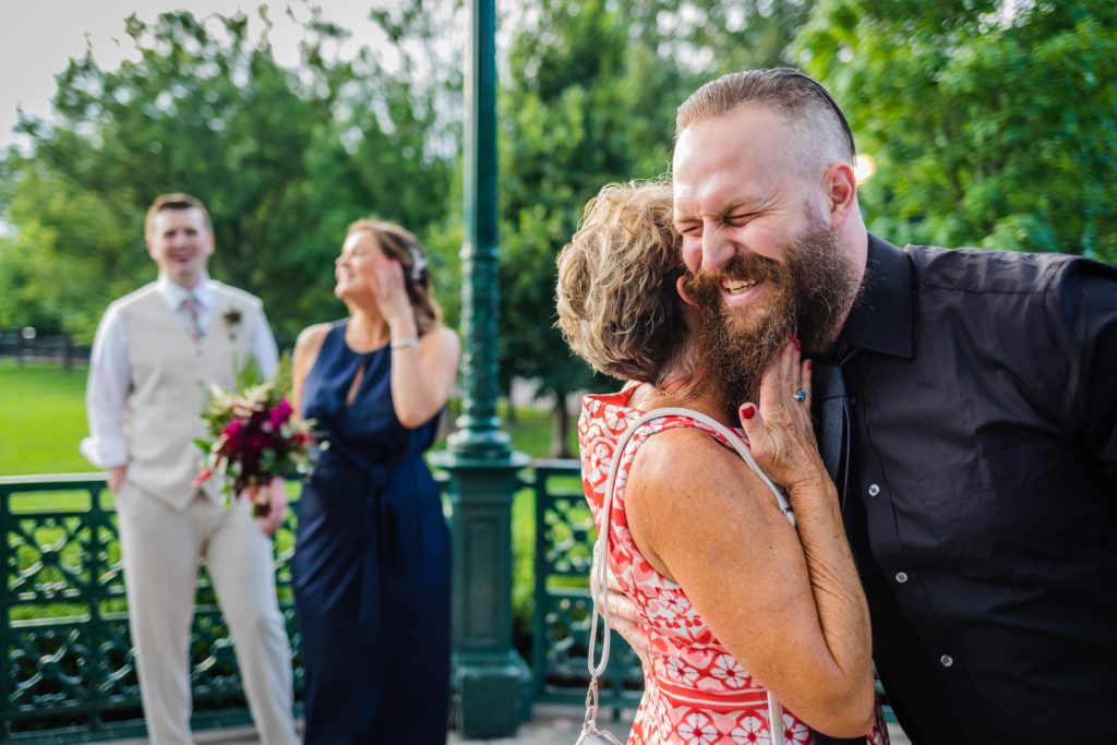 Mother of the bride sticking her hands in the groom's beard