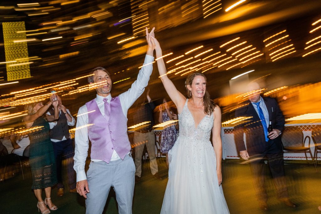 Bride and groom holding their hands up and smiling on Chicago's First Lady Cruise