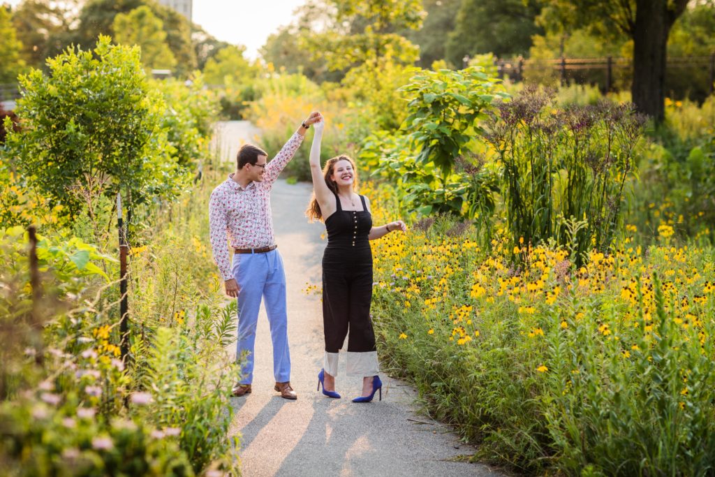 Man spinning woman on the sidewalk during their south pond engagement session