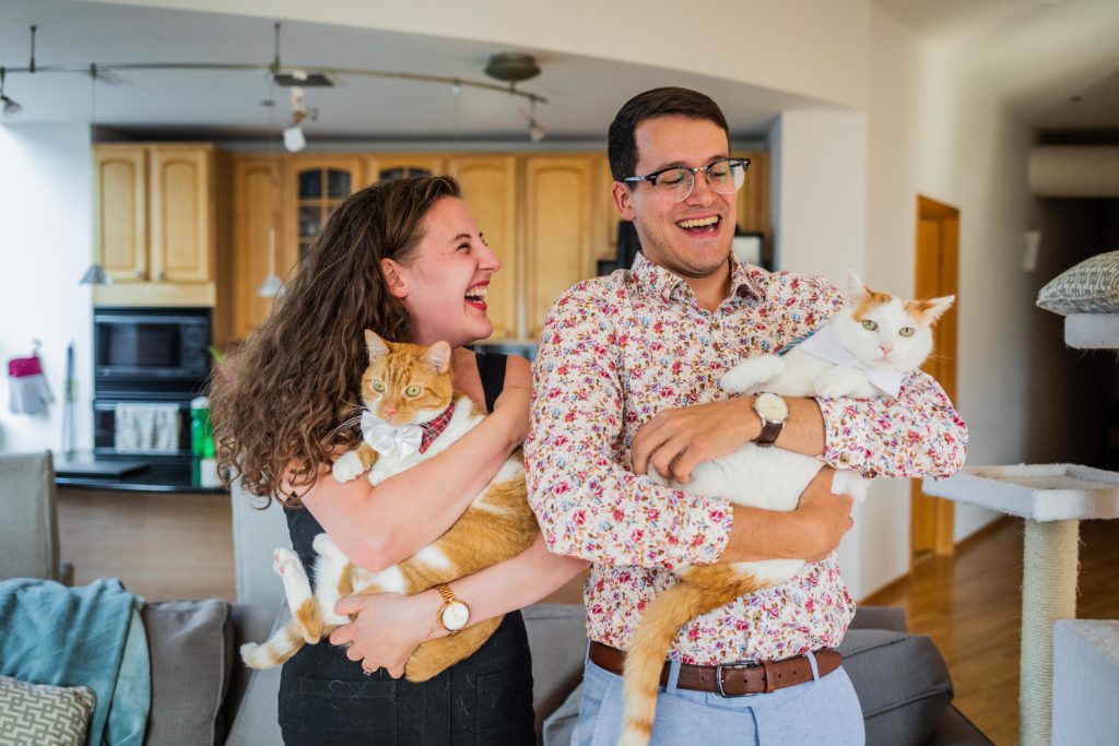 Couple laughing and holding cats