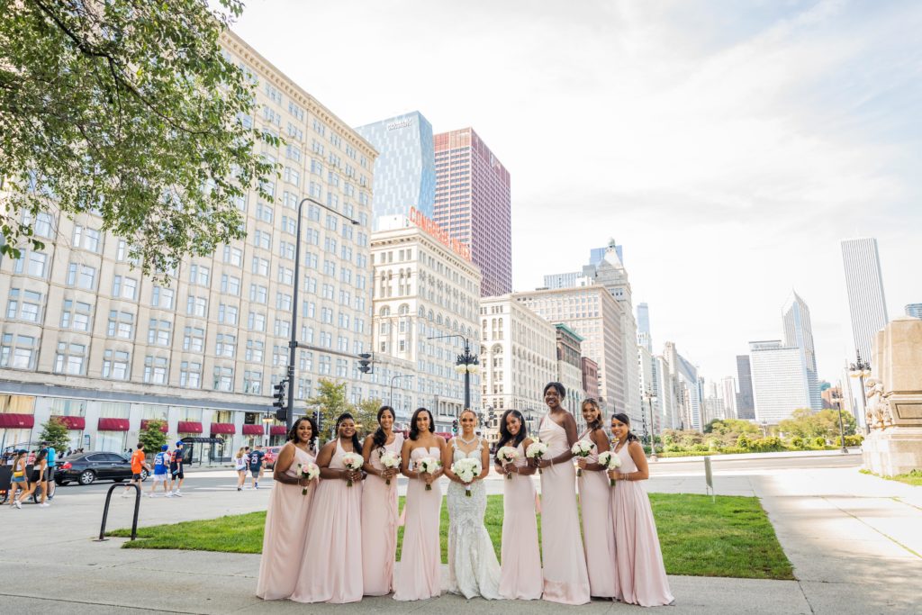 Bride and bridesmaids posing for a photos in front of the Chicago skyline before the wedding at Venue SIX10