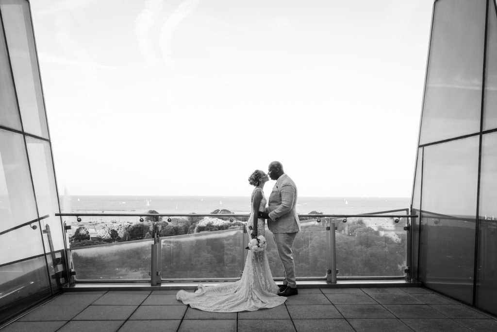 Bride and groom kissing on the balcony during their wedding at Venue SIX10