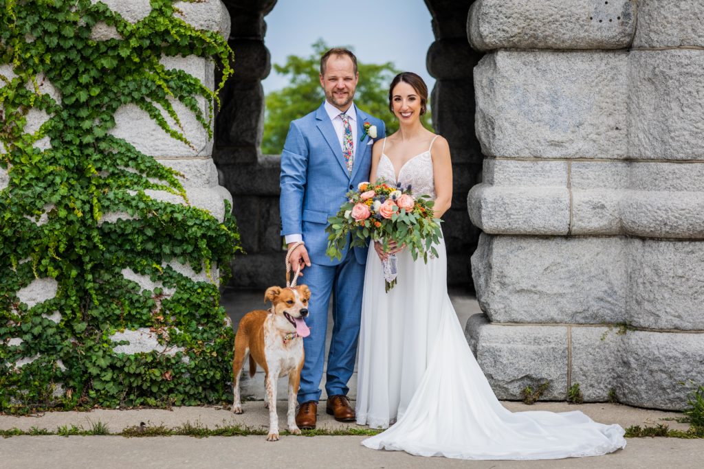 Bride and groom standing with their dog in the South Pond in Chicago