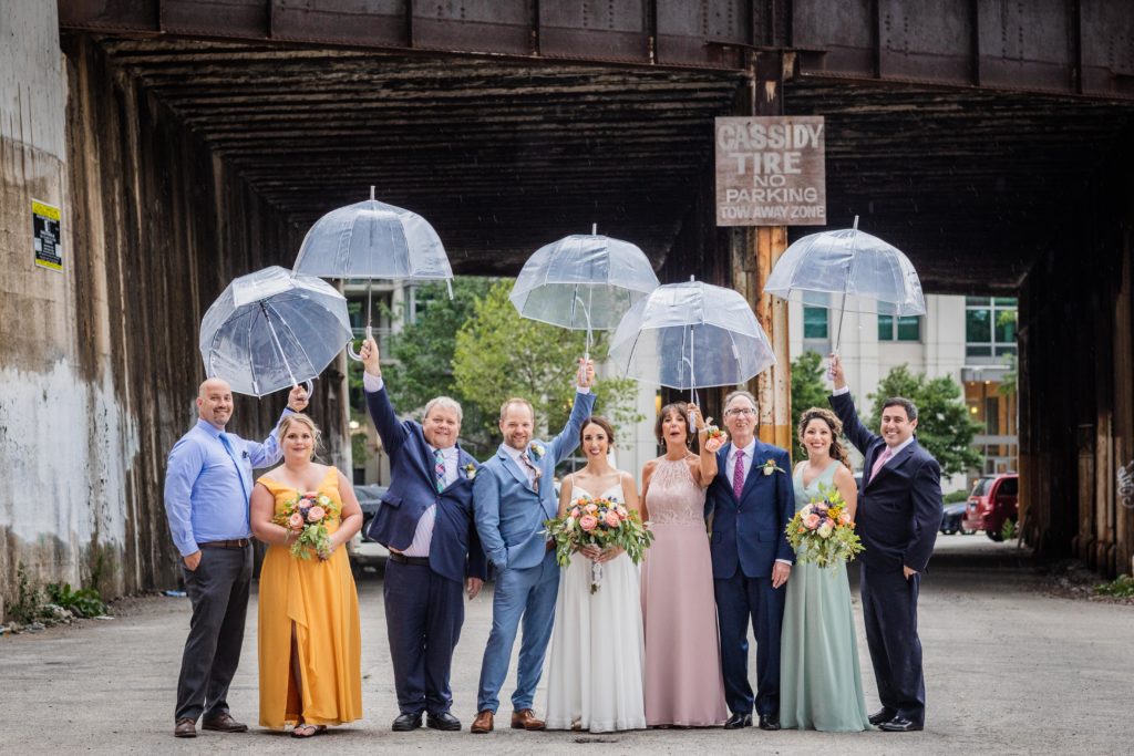 Wedding party holding up umbrellas in Chicago