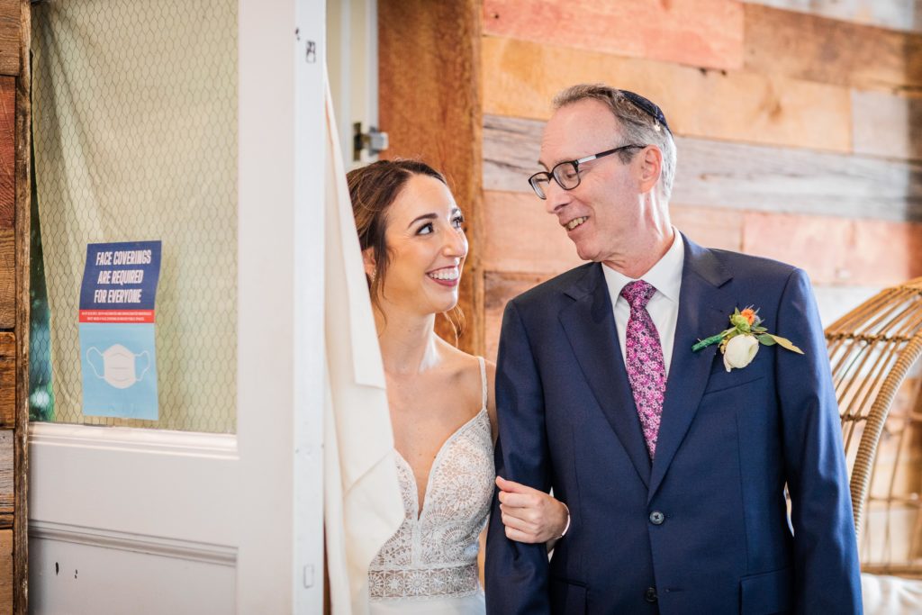 Bride and her father looking at each other before he walks her down the aisle