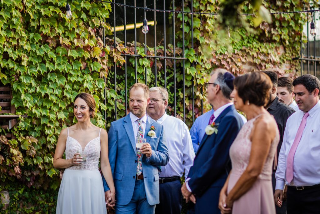 Wedding guests smiling while the groom's sister makes a speech